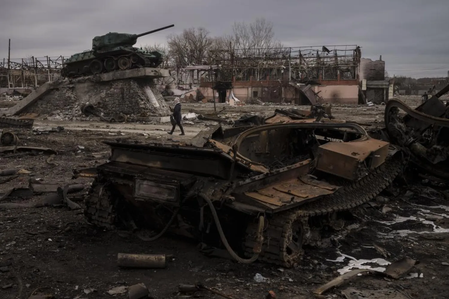 A woman walks past a destroyed tank in the town of Trostsyanets, Ukraine, Monday, March 28, 2022. (AP)