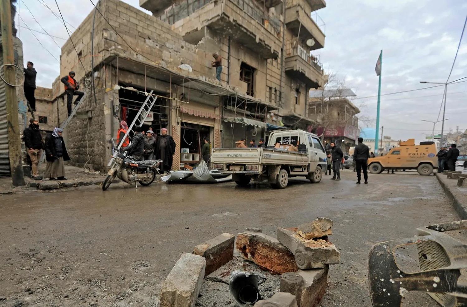 People gather around a damaged building following reported artillery shelling, northern Aleppo province, Syria, Feb. 2, 2022. (AFP)