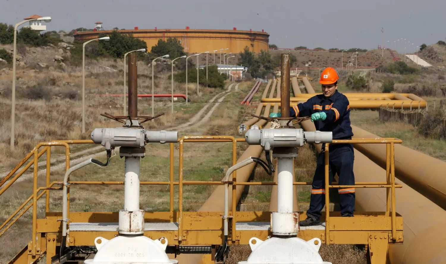 A worker checks the valve gears of pipes linked to oil tanks at Turkey's Mediterranean port of Ceyhan, which is run by state-owned Petroleum Pipeline Corporation (BOTAS), some 70 km (43.5 miles) from Adana February 19, 2014. (Reuters)