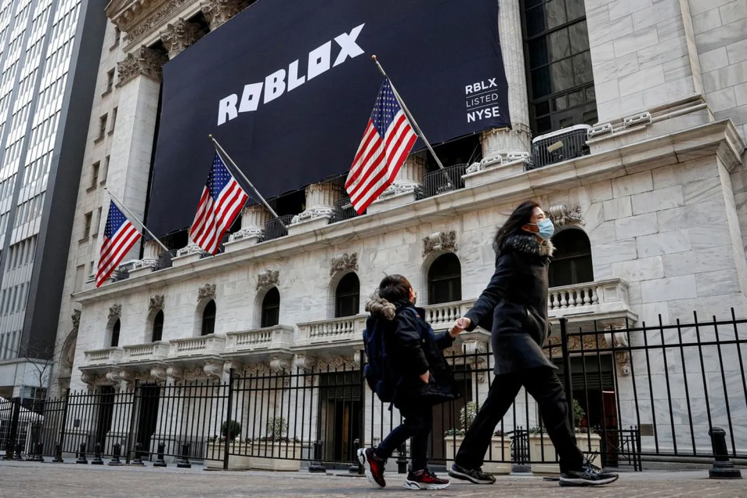 A child looks back at a banner for Roblox, displayed to celebrate the company's IPO, on the front facade of the New York Stock Exchange (NYSE) in New York, US, March 10, 2021. (Reuters)