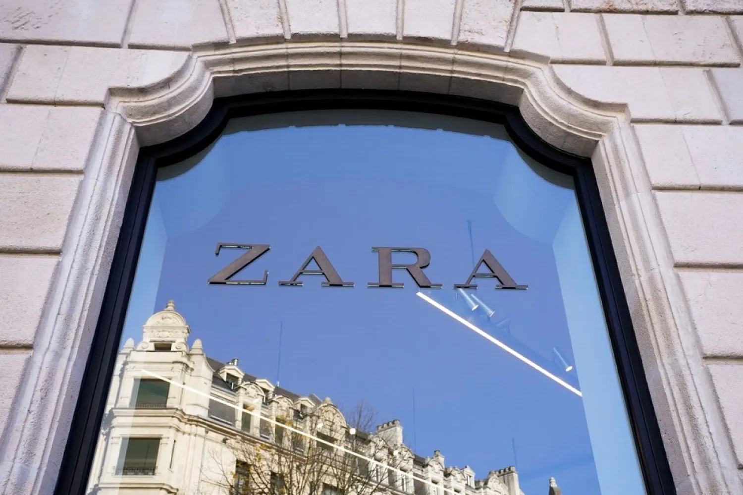 A building is reflected in the window of a Zara clothes store, part of the Spanish Inditex group, in Bilbao, Spain, November 30, 2021. (Reuters)