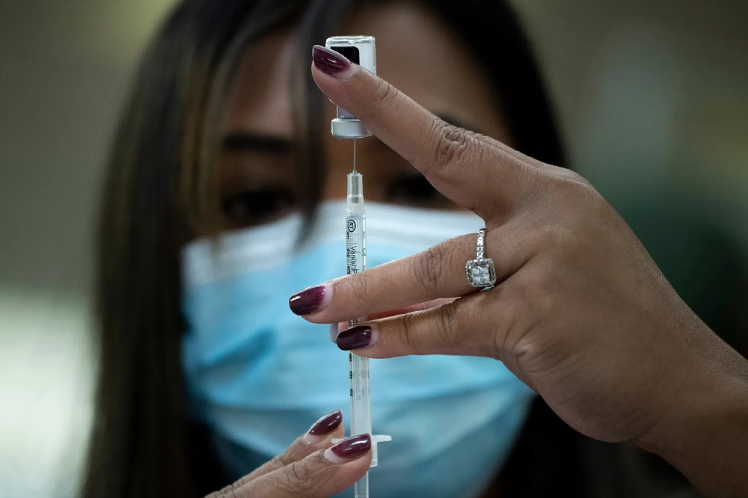 A pharmacist dilutes the Pfizer COVID-19 vaccine while preparing it to administer to staff and residents at the Goodwin House Bailey’s Crossroads, a senior living community in Falls Church, Virginia, on December 30, 2020. (Getty Images)