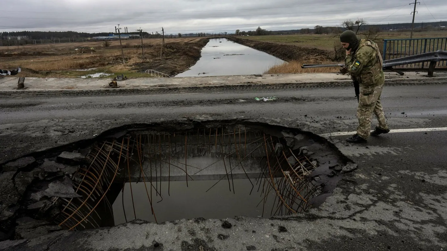 A Ukrainian soldier looks at a damaged bridge in Bucha, on the outskirts of Kyiv, on Saturday. (AP)