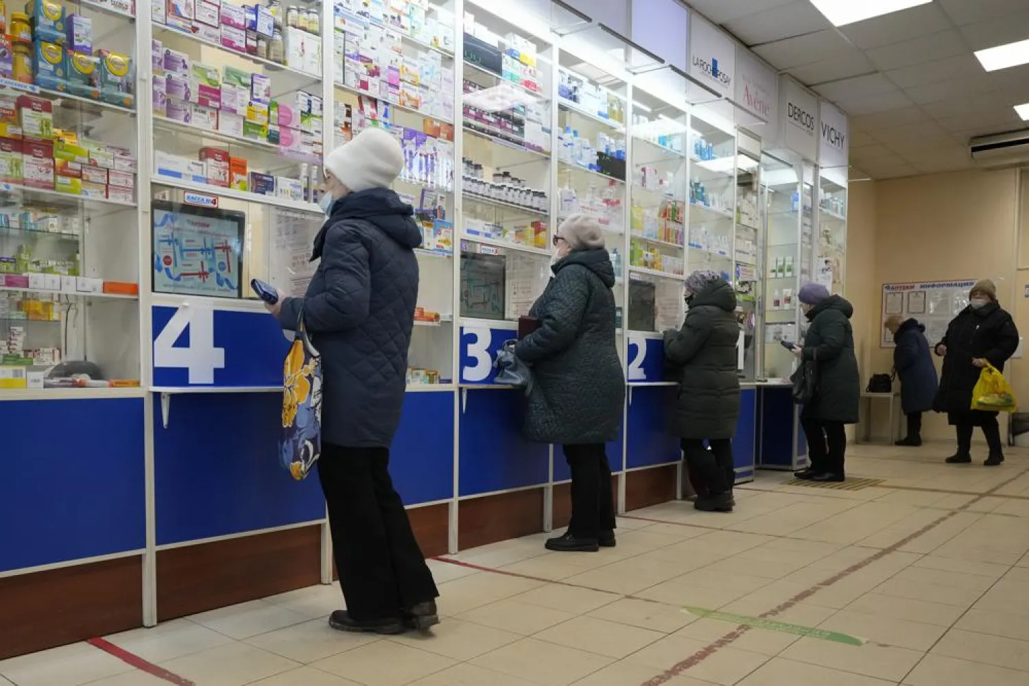 Customers stand at the windows buying medicines in a pharmacy in St. Petersburg, Russia, Friday, April 1, 2022. (AP)