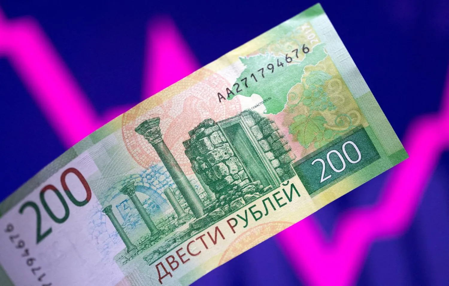 A Russian rouble banknote is seen in front of a descending and rising stock graph in this illustration taken March 1, 2022. (Reuters)
