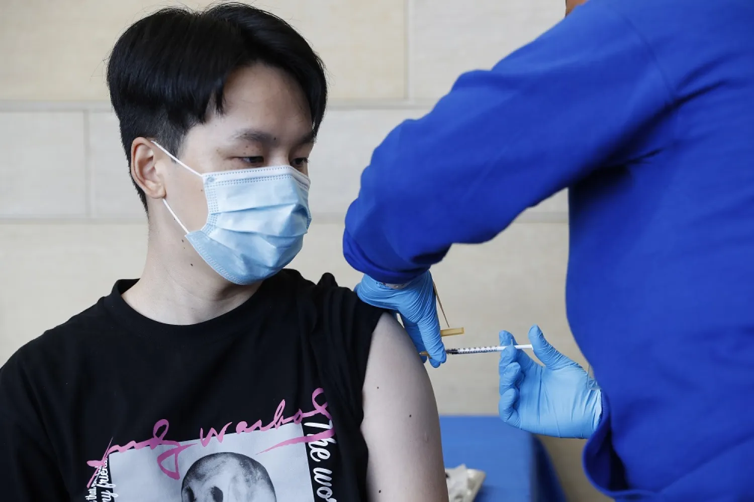 A healthcare worker administers a Pfizer Covid-19 booster shot at a vaccination clinic at Union Station in Los Angeles, California, USA, 30 March 2022. (EPA)