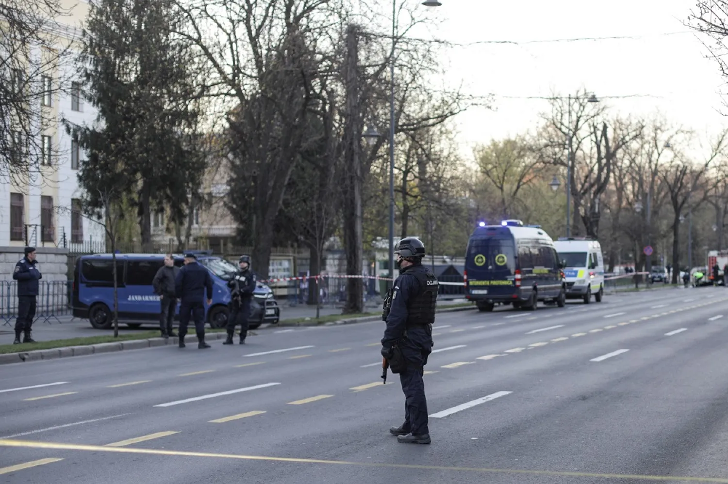 Police officers stand guard as crime scene investigators check the area where a car crashed into the gate of the Russian Embassy in Bucharest, Romania, April 6 2022. (Reuters)