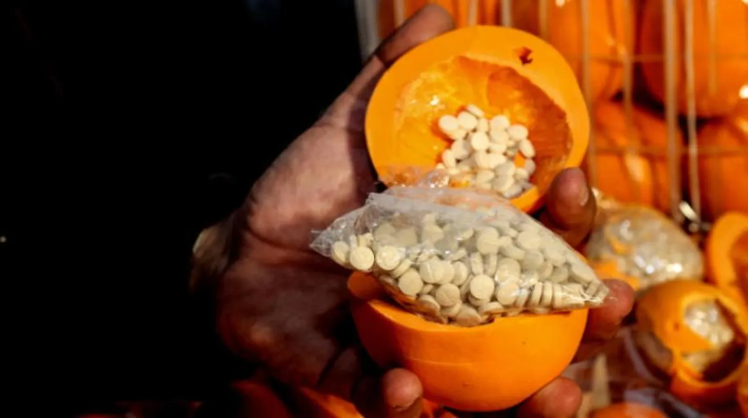A man shows fake oranges filled with Captagon pills and dissimulated in boxes containing real fruit, after the shipment was intercepted at the Beirut port on December 29, 2021. (AFP)