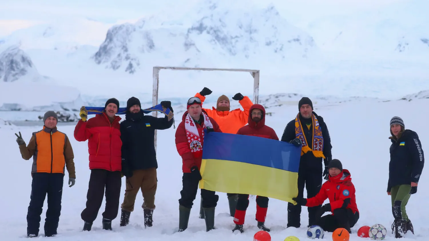 Ukranian scientists at the Vernadsky Antarctic base hold a national flag Oksana SAVENKO Ukrainian Antarctic Akademik Vernadsky Station/AFP

