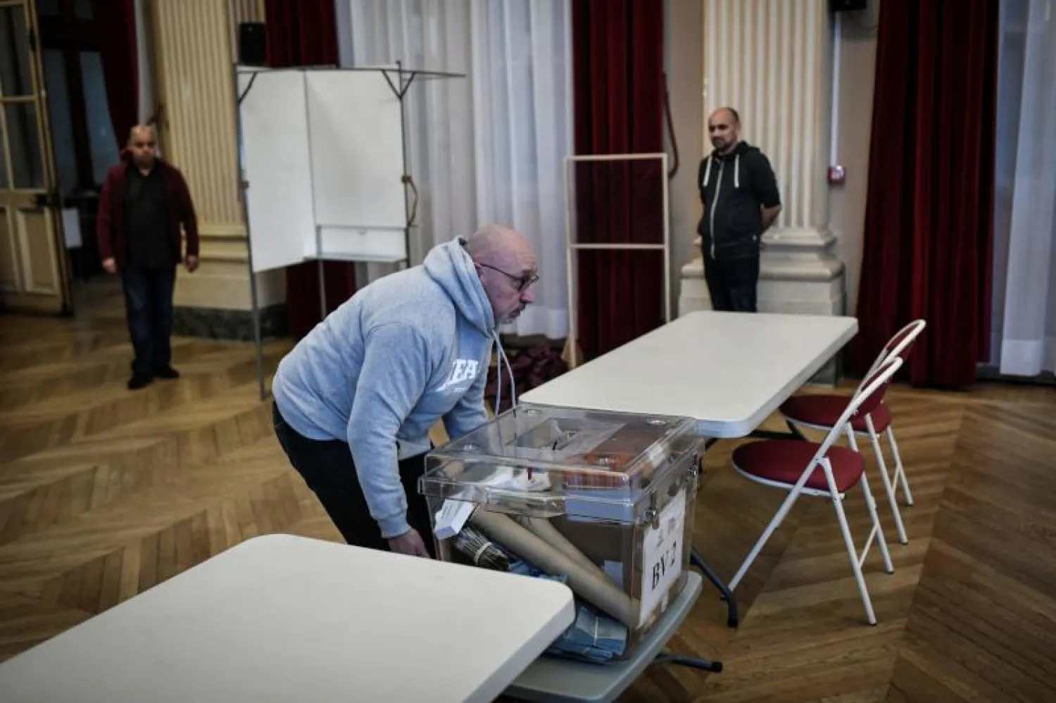 عمال يجهّزون مركزاً للاقتراع في باريس (أ.ف.ب)