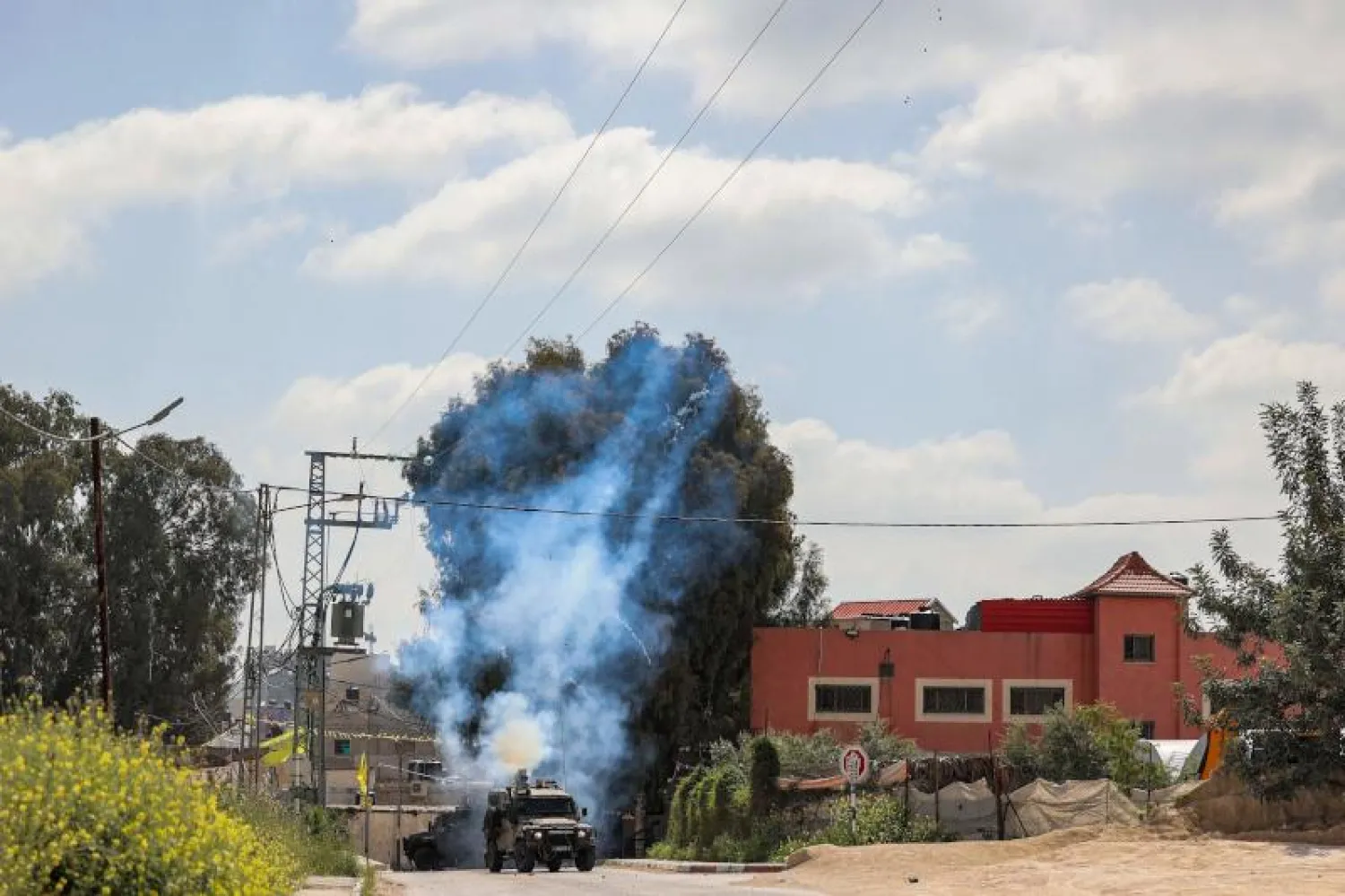 مركبة عسكرية إسرائيلية تطلق قنابل غاز مسيل للدموع في مخيم جنين (أ.ف.ب)