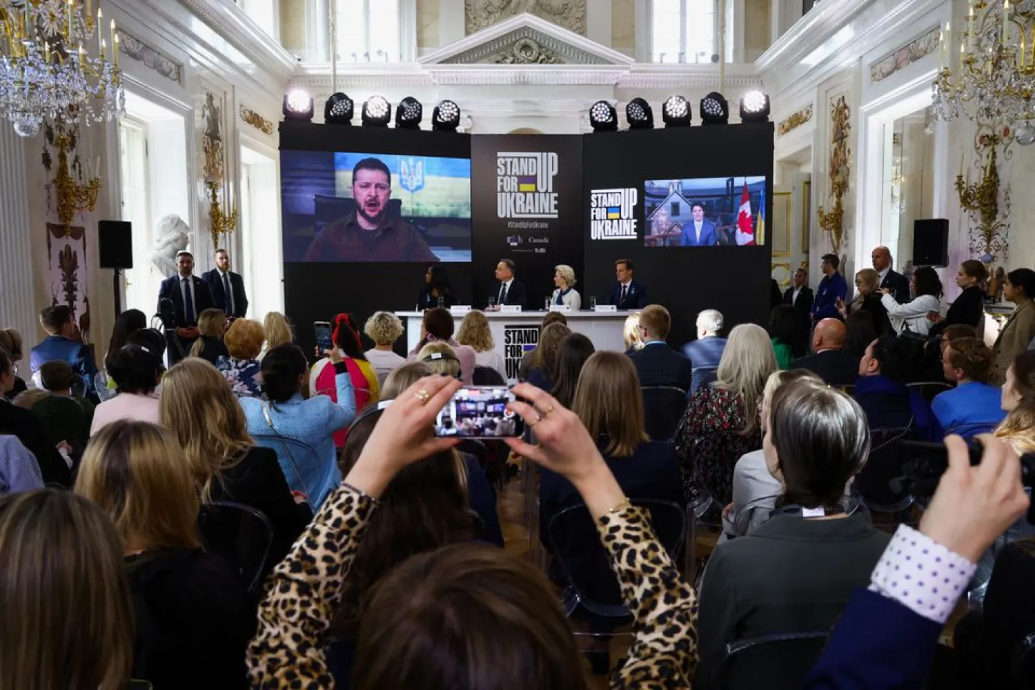 Ukrainian President Volodymyr Zelenskiy and Canadian Prime Minister Justin Trudeau are seen on a screens as they participate remotely in a global event titled 'Stand Up For Ukraine' along with European Commission President Ursula von der Leyen and Polish President Andrzej Duda, at the Palace on the Isle in Royal Lazienki Park in Warsaw, Poland, April 9, 2022. (Reuters)