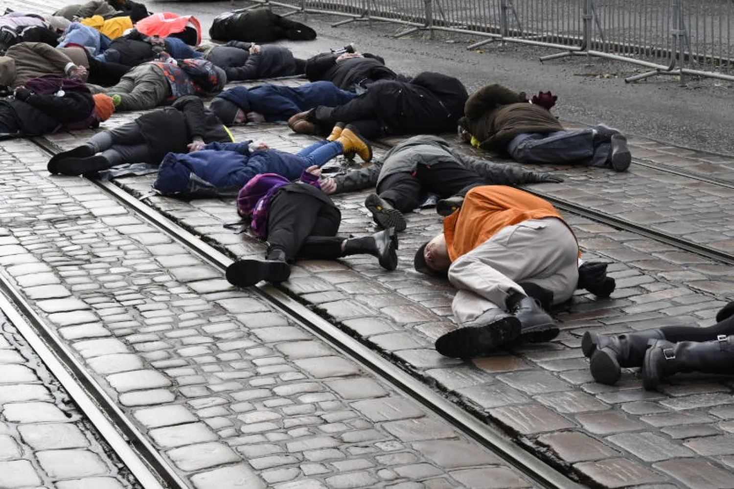 محتجون على مذبحة بوتشا يستلقون أرضاً أمام السفارة الروسية بالعاصمة الفنلندية هلسنكي (رويترز)