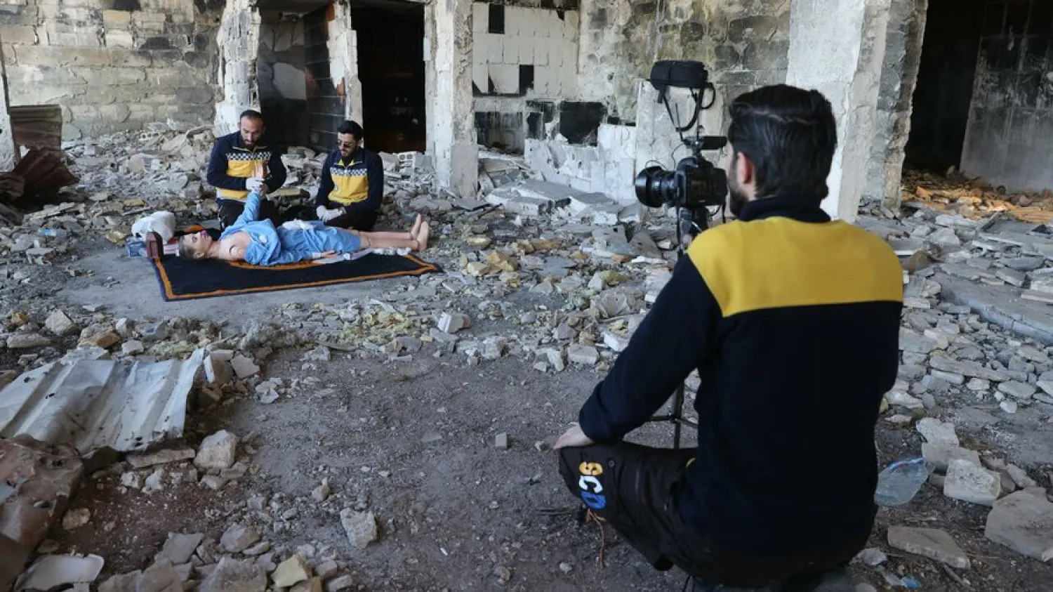 Members of the Syrian civil defense known as the White Helmets use a dummy to demonstrate their rescue skills during a video shoot for an instructive film intended for Ukrainian rescuers, in the war-ravaged Syrian town of Ariha. Omar Haj Kadour/ AFP