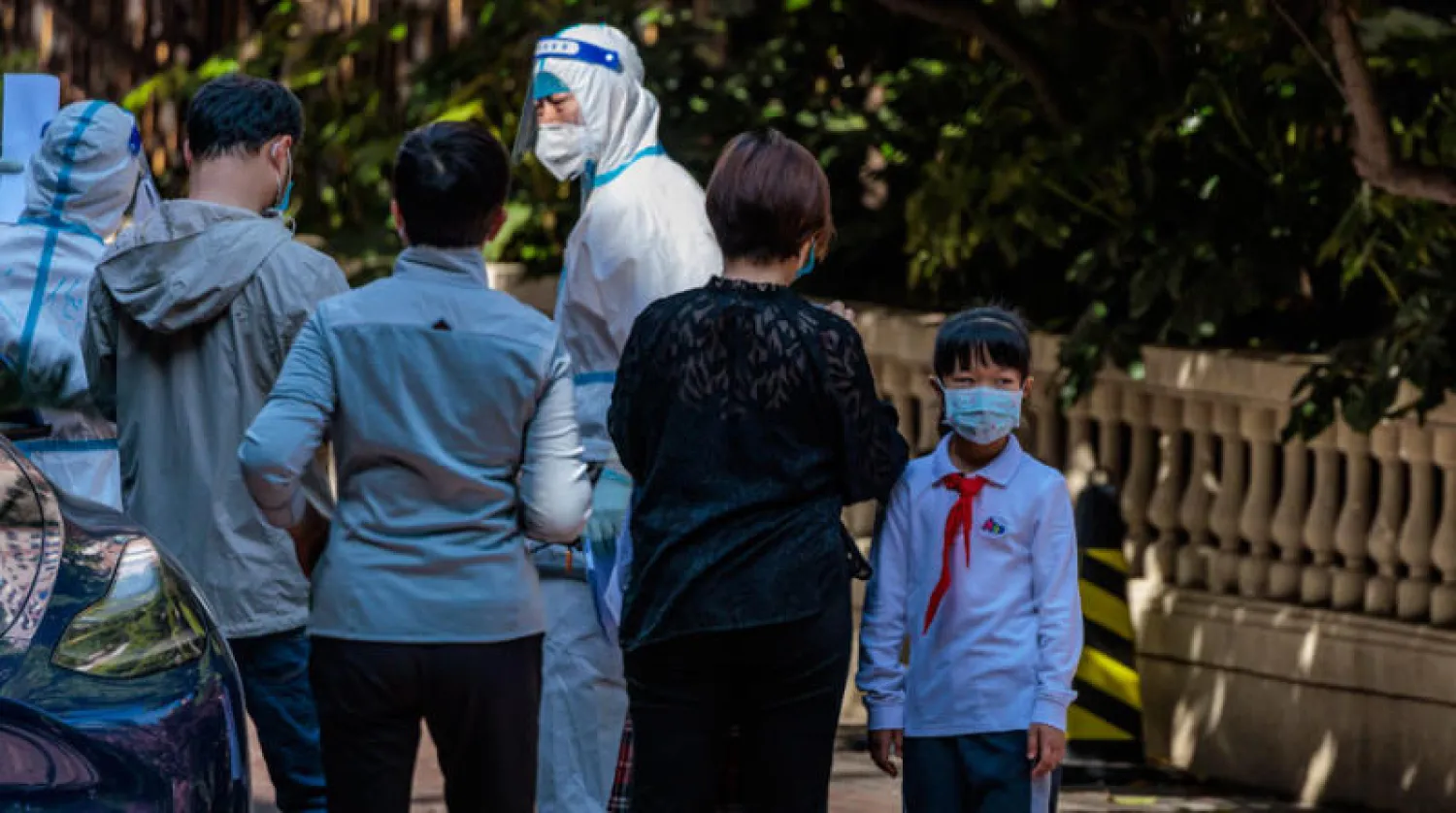 أشخاص يقفون لتلقي لقاح كورونا في مجمع سكني يخضع للإغلاق في شنغهاي  أمس (إ.ب.أ)