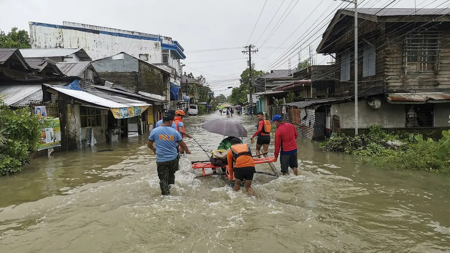 Philippine Coast Guard personnel evacuate a resident from a flooded area of Leyte province following tropical storm Megi - Philippine Coast Guard (PCG)/AFP
