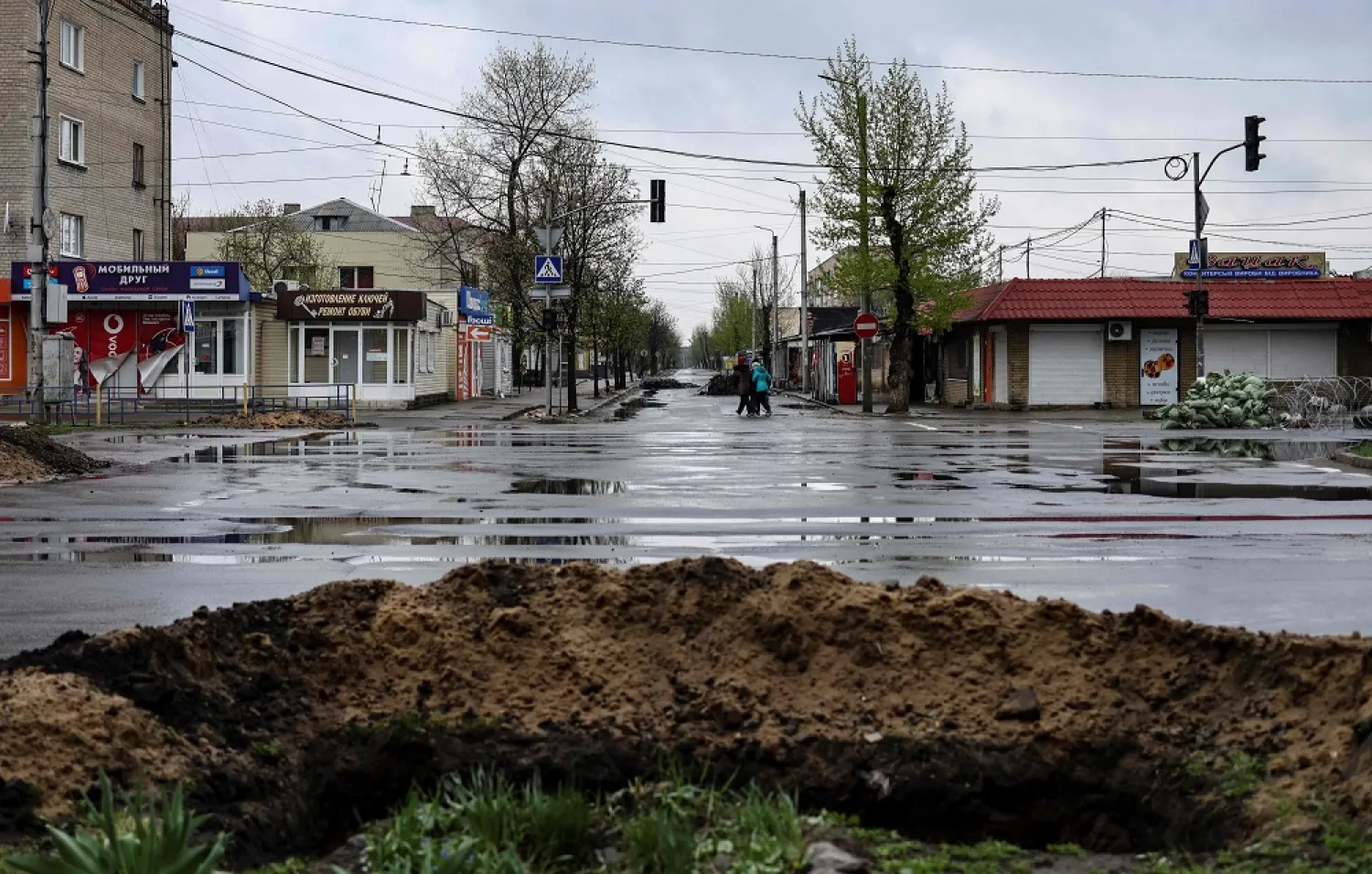 People walk in an empty street in Severodonetsk, in eastern Ukraine's Donbass region, on April 13, 2022. (AFP)