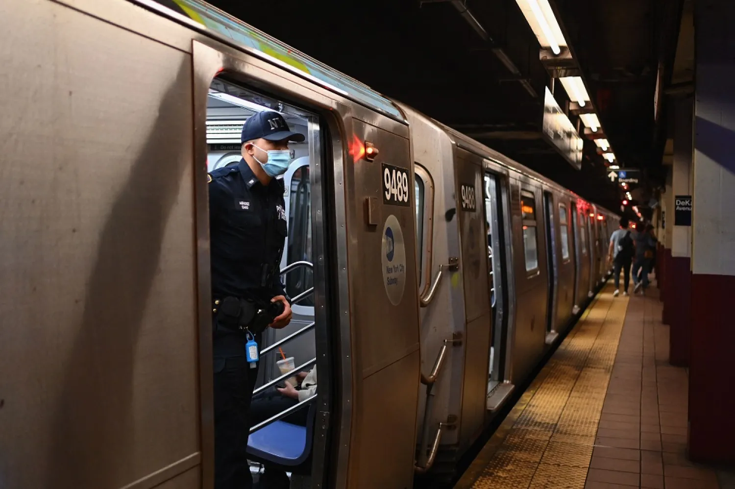 A NYPD officer looks out of a subway car in New York City on April 13, 2022, one day after people were injured during a rush-hour shooting in the Brooklyn borough of New York. (AFP)