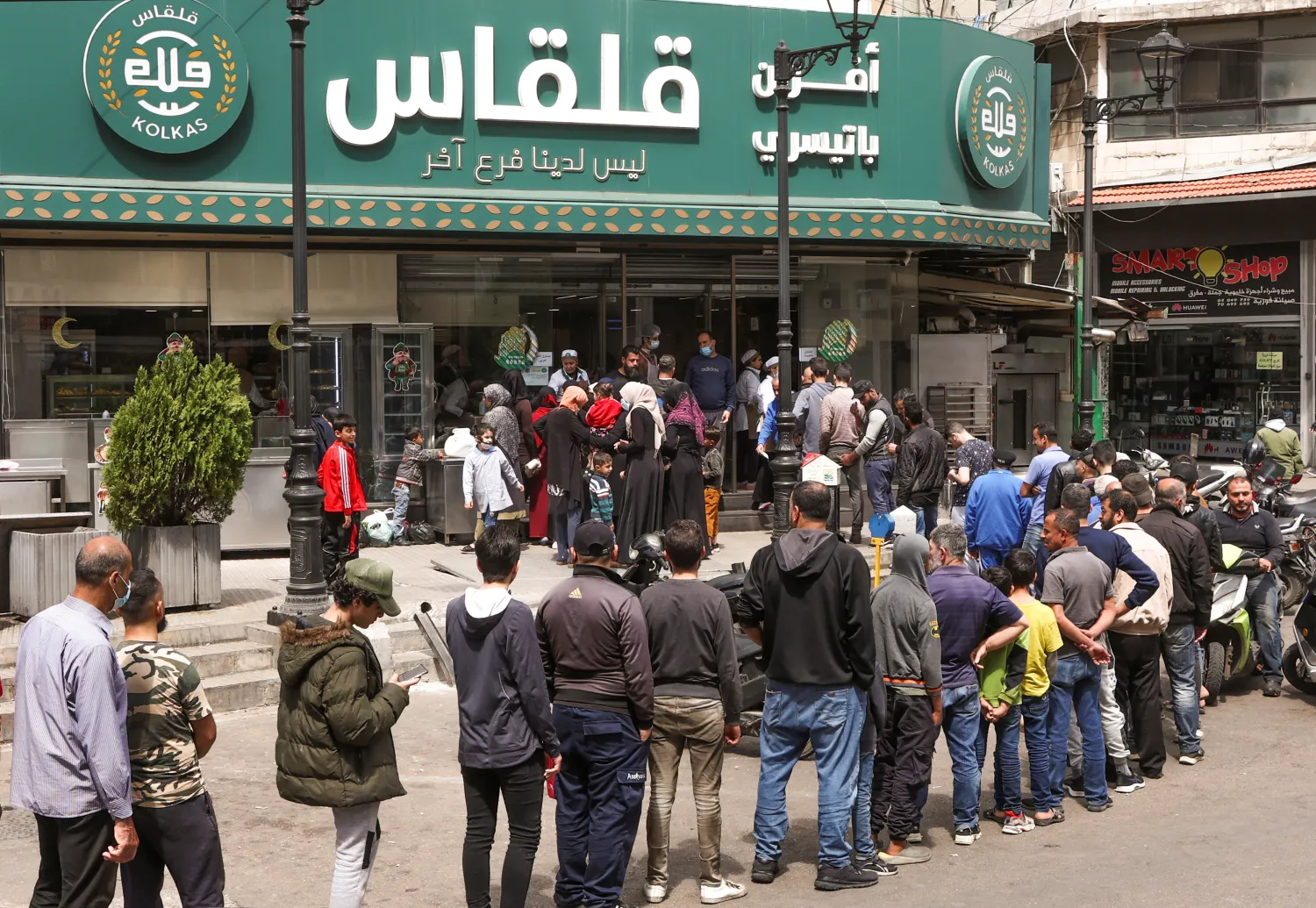 People queue to buy bread outside a bakery in Beirut, April 12, 2022. (Reuters)
