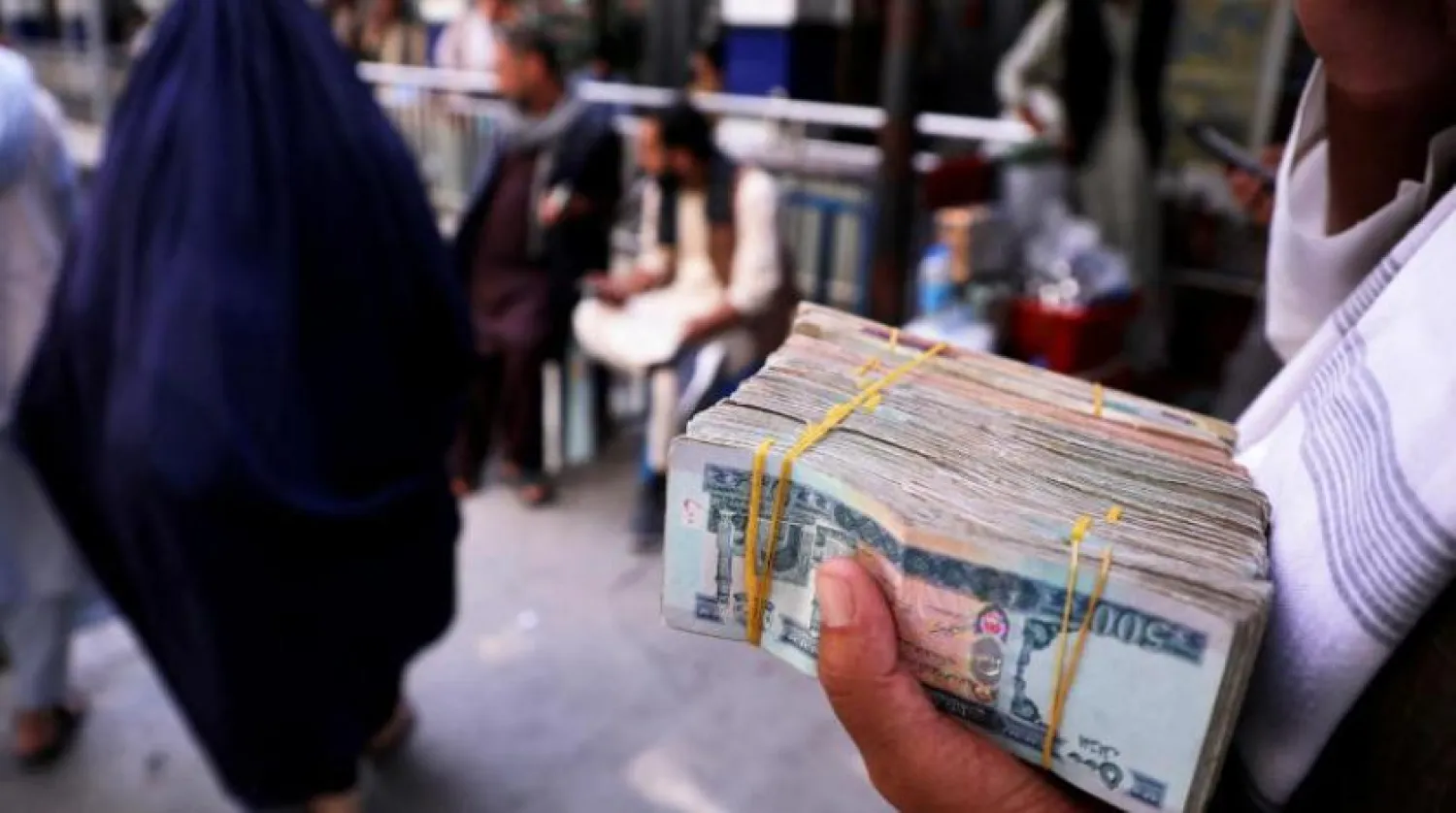 Kabil’de bir adam Afgan parası taşırken (Reuters)