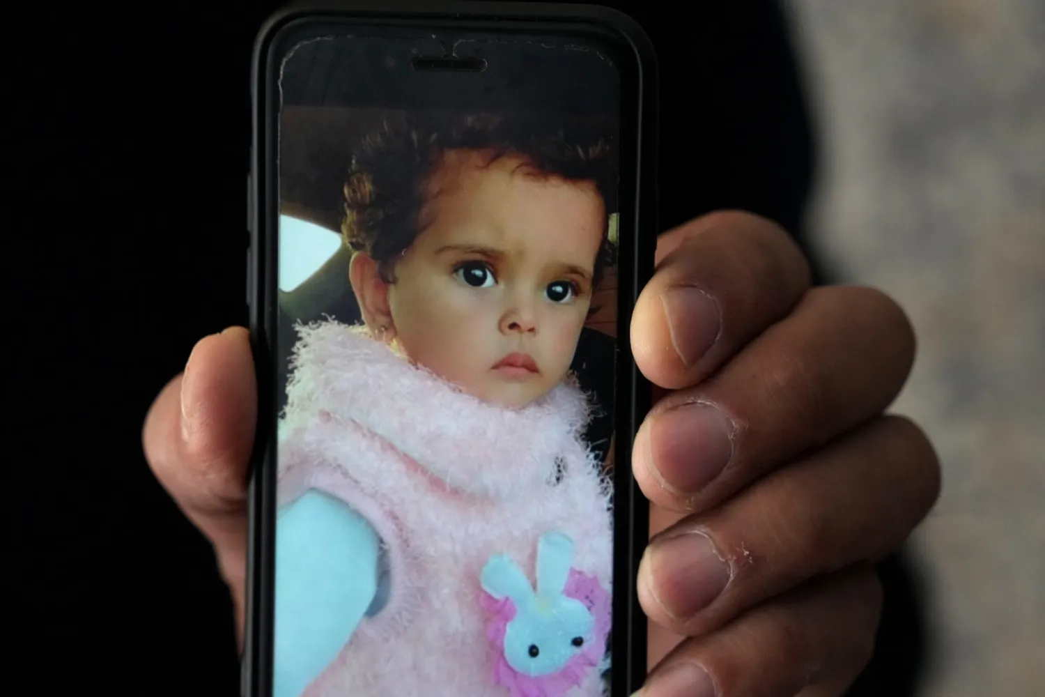 Jalal al-Masri holds a picture of his daughter, Fatma, a 19-month-old who was diagnosed with a congenital heart defect in December 2021, and died as the family waited another three months for an Israeli permit to take her for treatment outside the Gaza Strip, in Khan Younis, southern Gaza Strip, Tuesday, April 12, 2022. (AP Photo/Adel Hana)