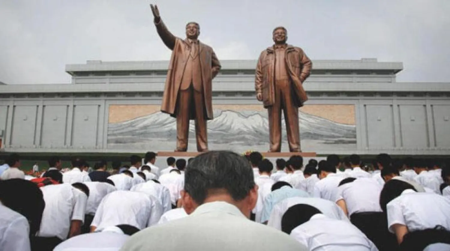 مواطنون من كوريا الشمالية أمام تماثيل برونزية للقادة السابقين كيم إيل سونغ وكيم جونغ إيل في جبل منسو في بيونغ يانغ كوريا الشمالية أمس (أرشيفية - أ.ب)