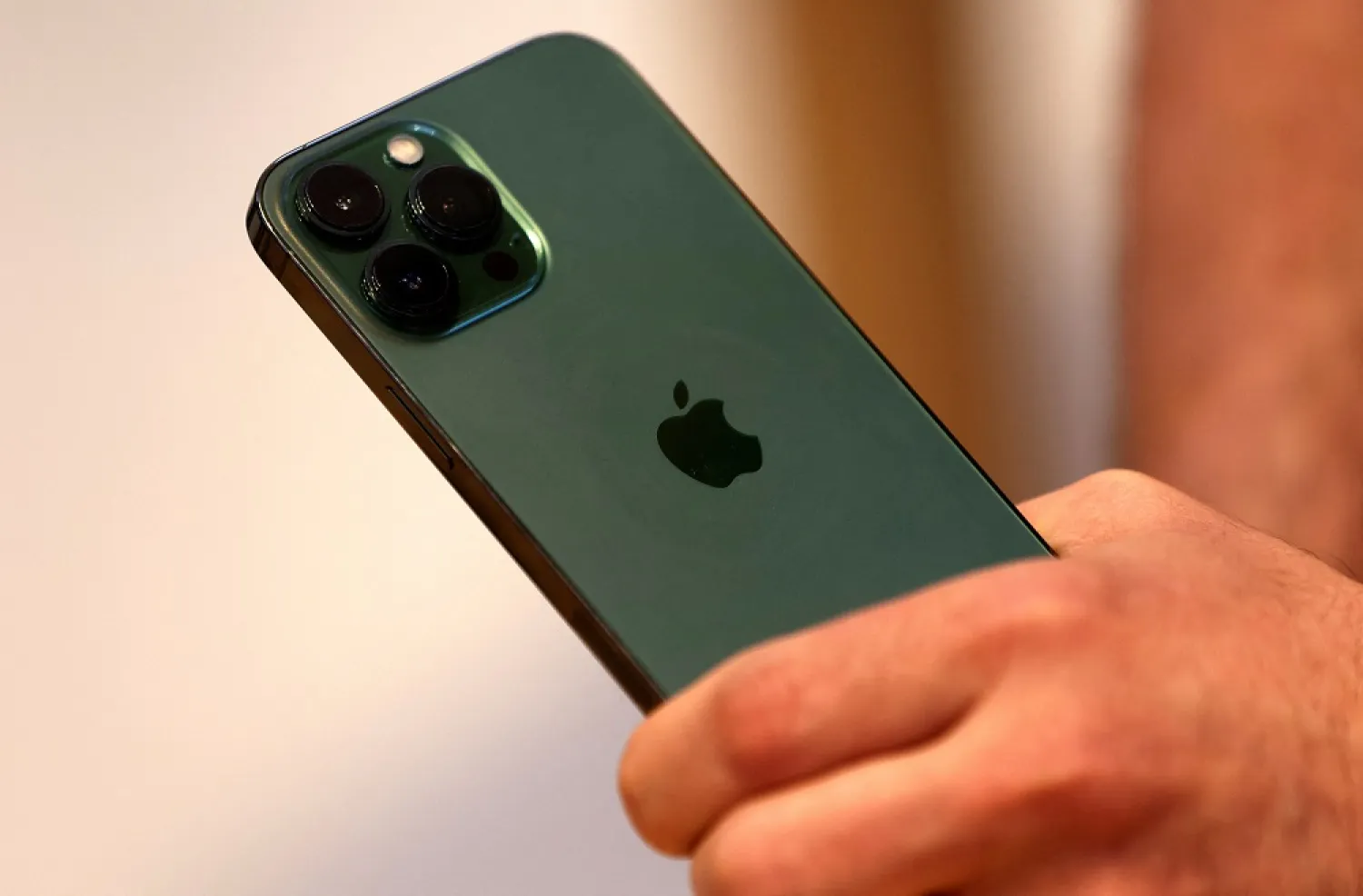 A customers holds the new green color Apple iPhone 13 pro shortly after it went on sale inside the Apple Store on 5th Avenue in Manhattan in New York City, New York, US, March 18, 2022. (Reuters)