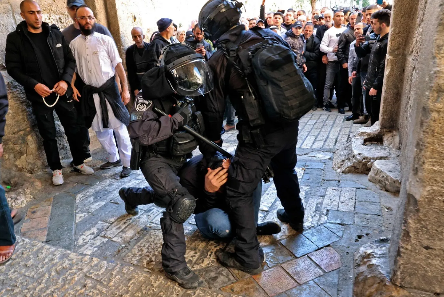 Israeli security forces immobilize a Palestinian man at an entrance to the Al-Aqsa mosque compound as others are prevented from entering, on April 15, 2022. (AFP)