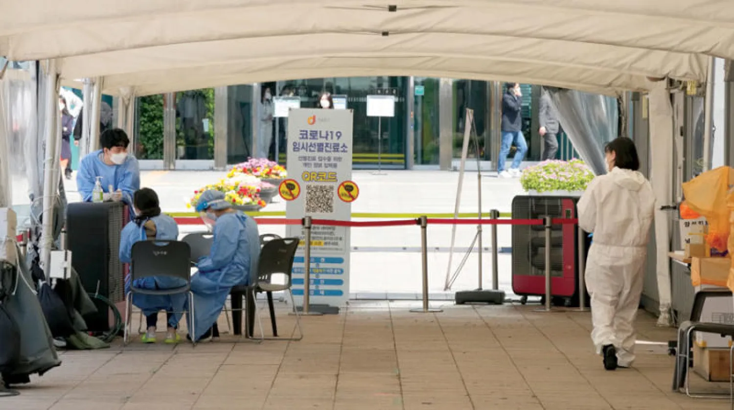 عاملون ينتظرون في مركز اختبار مؤقت في سيول أمس (أ.ب)