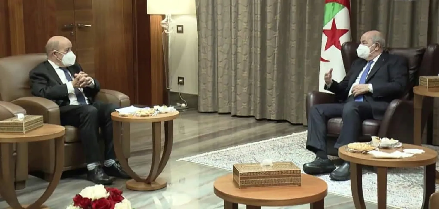 Algeria's President Abdelmadjid Tebboune (R) meets with French Foreign Minister Jean-Yves Le Drian (L) in Algiers. (AFP)