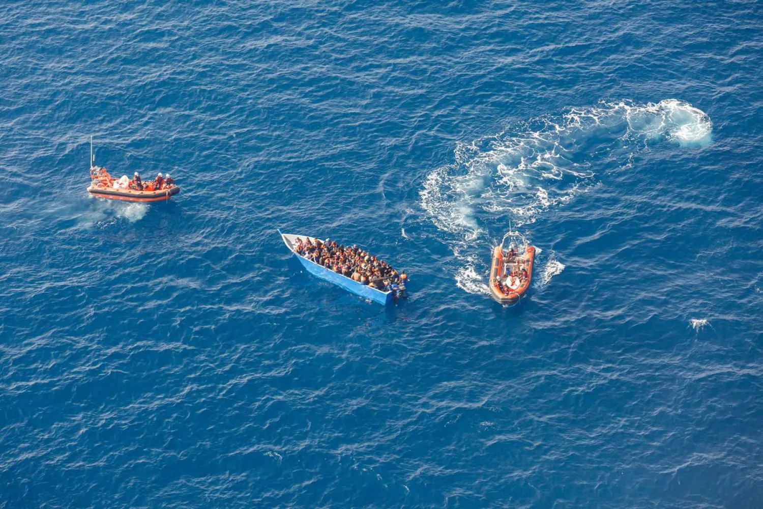 Members of the German charity Sea-Watch 3 rescue ship team help migrants on a wood boat during a rescue operation in the Mediterranean Sea, February 26, 2021. Selene Magnolia/Sea-Watch/Handout via REUTERS