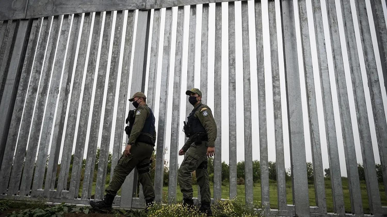 Police officers patrol alongside a steel wall at Evros river, near the Greek village of Poros. (AP file photo)