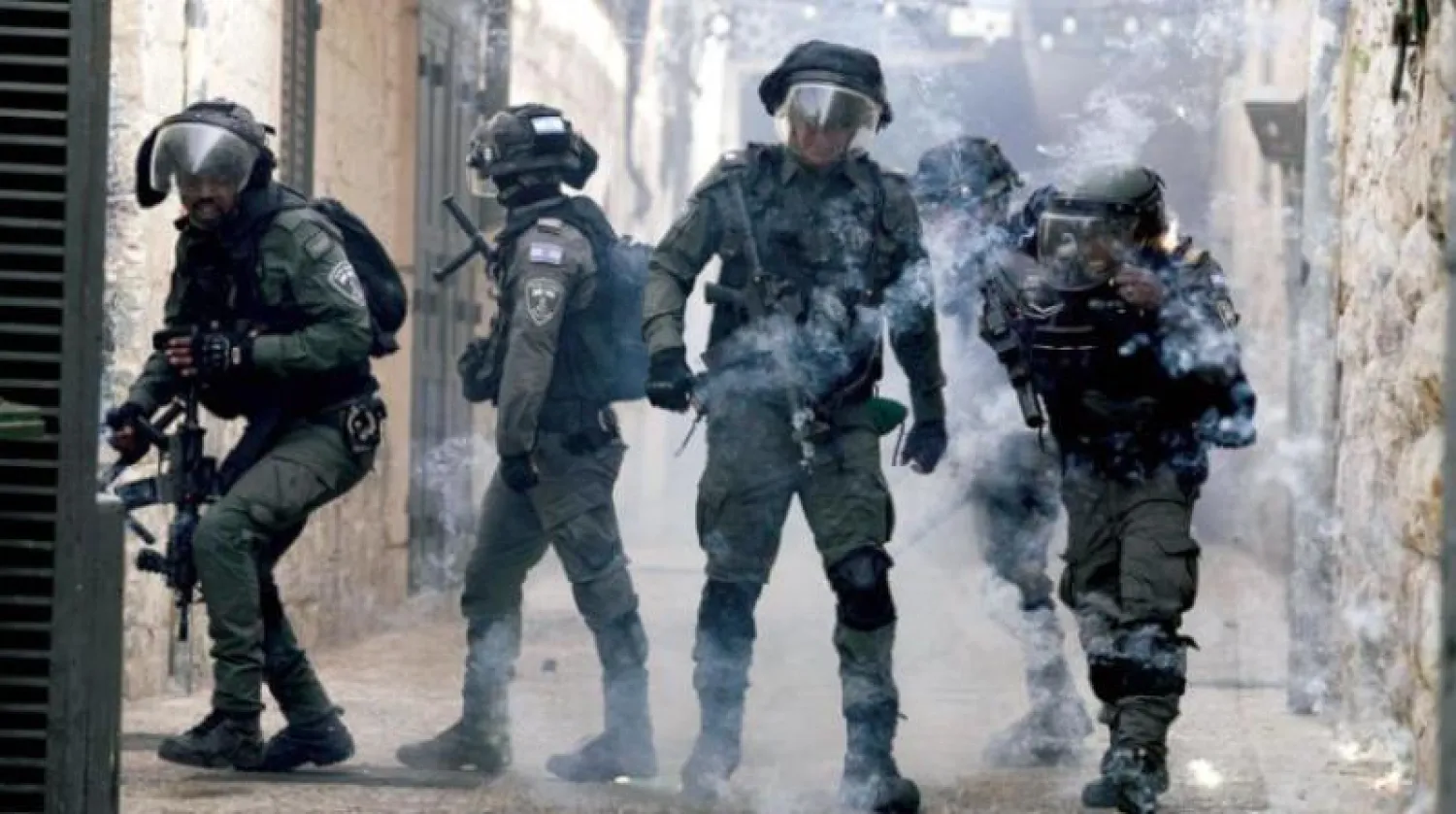 أفراد من الشرطة الإسرائيلية مع فلسطينيين خارج المسجد الأقصى (أ.ب)