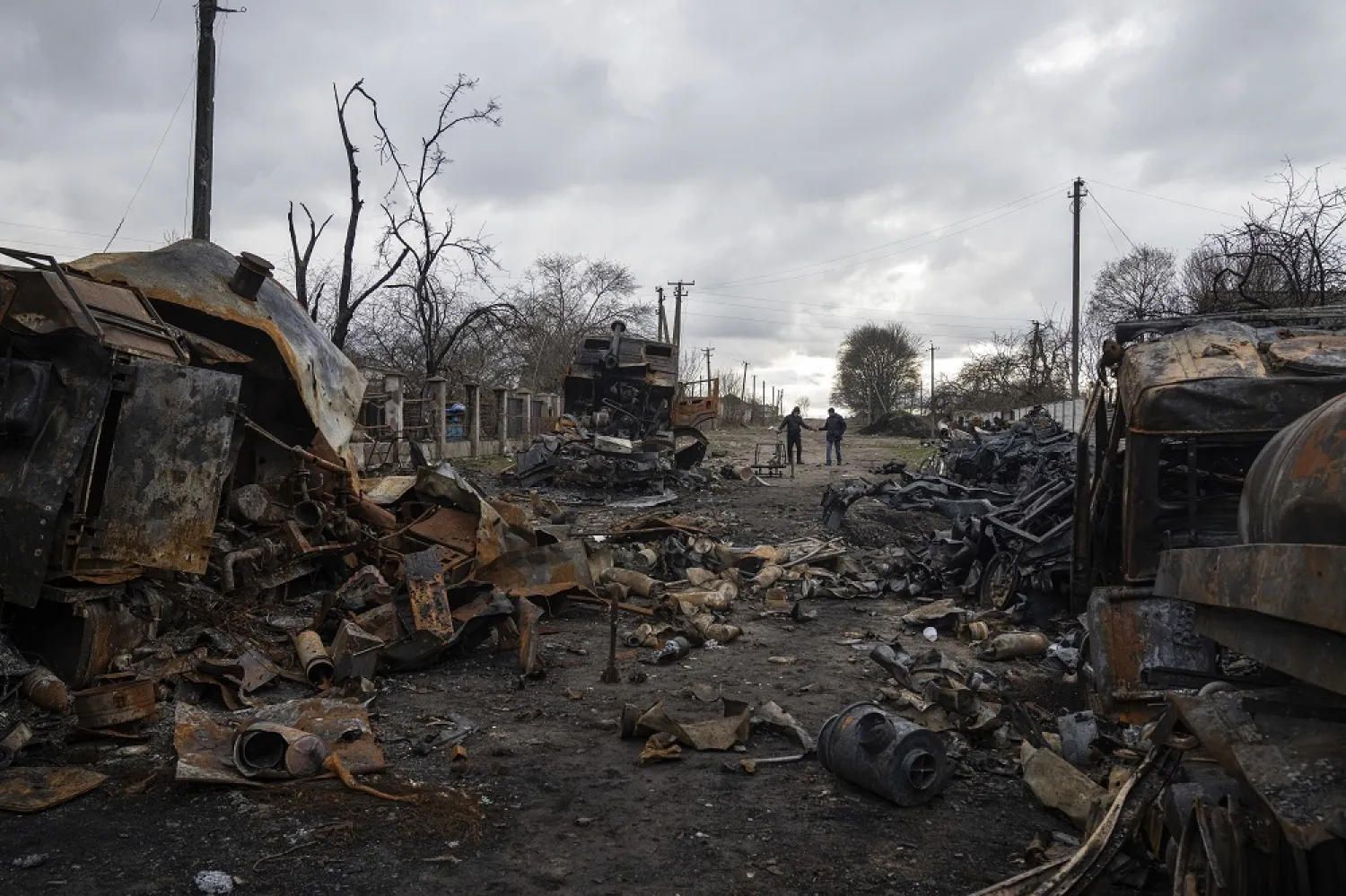 Men walk along a street filled with destroyed Russian military vehicles near Chernihiv, Ukraine, Sunday, April 17, 2022. (AP)