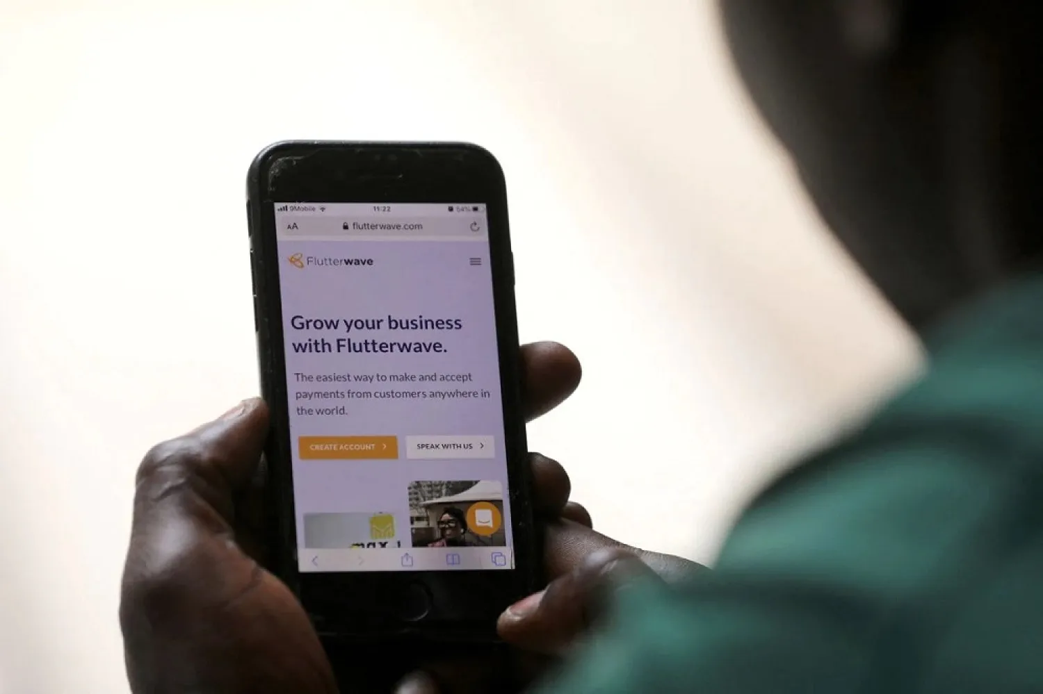 A man poses as he displays the Flutterwave homepage on a mobile phone screen in Abuja, Nigeria January 21, 2020. (Reuters)