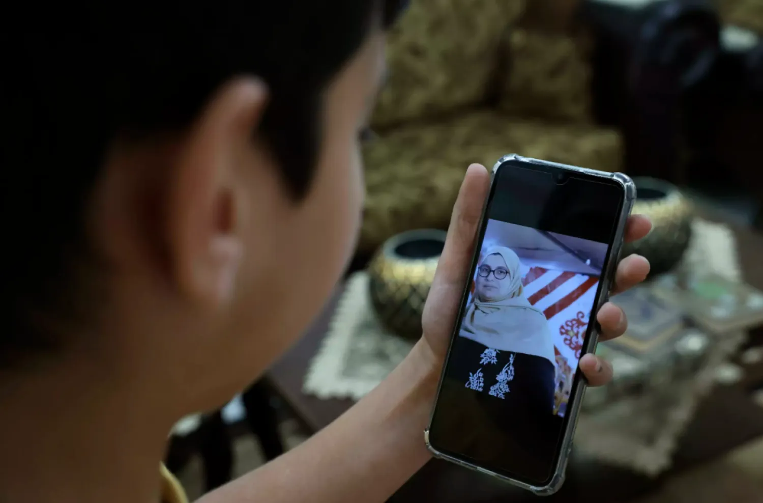 Omar displays a picture of his mother on a phone HAZEM BADER AFP