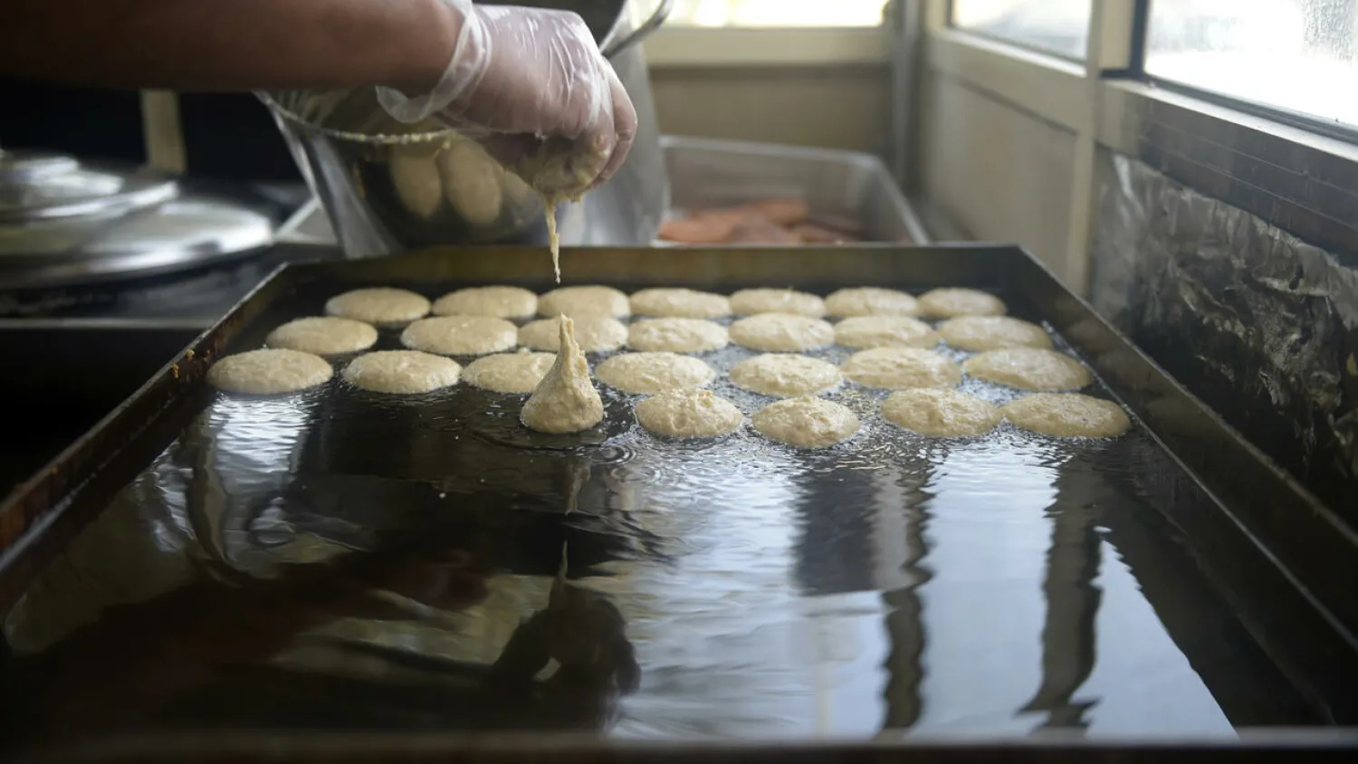 Saleh al-Halwaji prepares saffron and cardamom cakes at the family sweets shop on the outskirts of the Bahraini capital Manama Mazen Mahdi AFP
