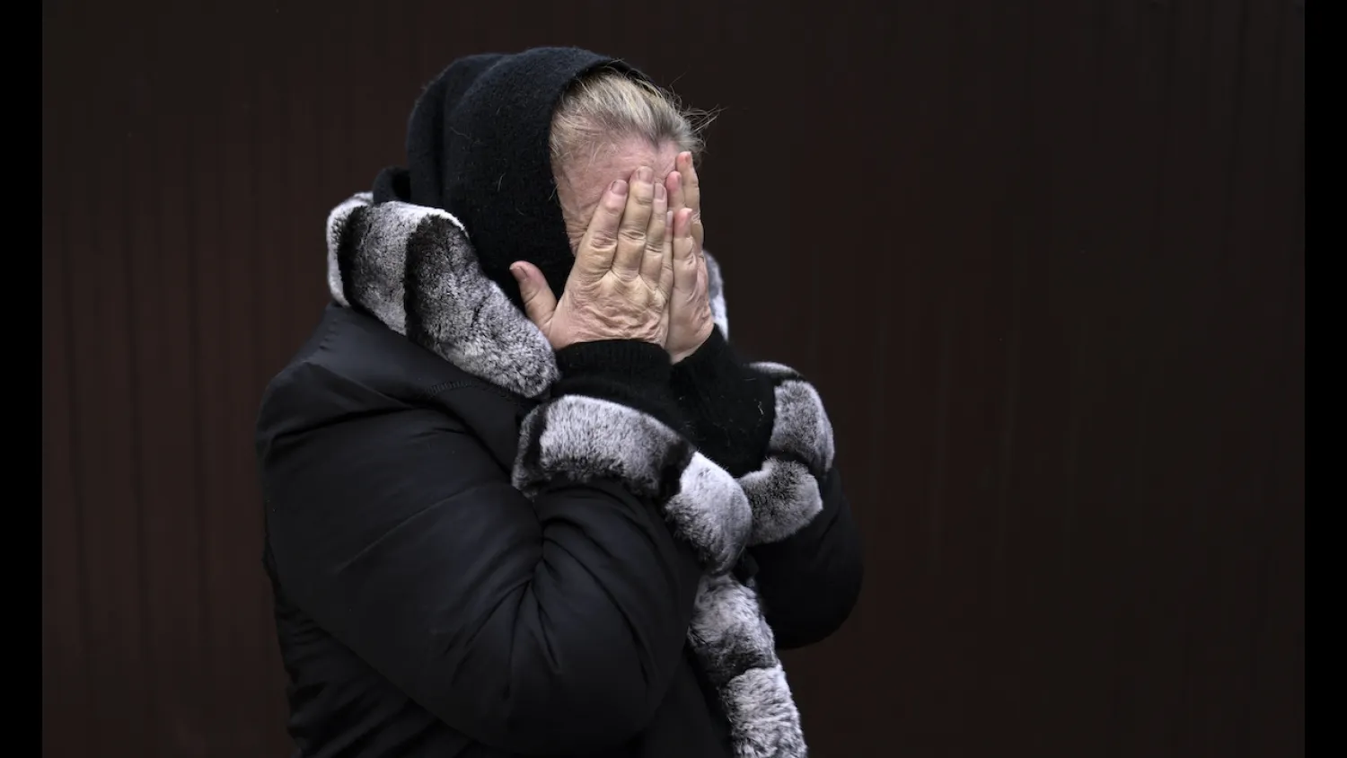Bucha resident Tetiana Ustymenko weeps over the grave of her son, who is buried in the garden of her home in Bucha, northwest of Kyiv, on April 6, 2022. (AFP)