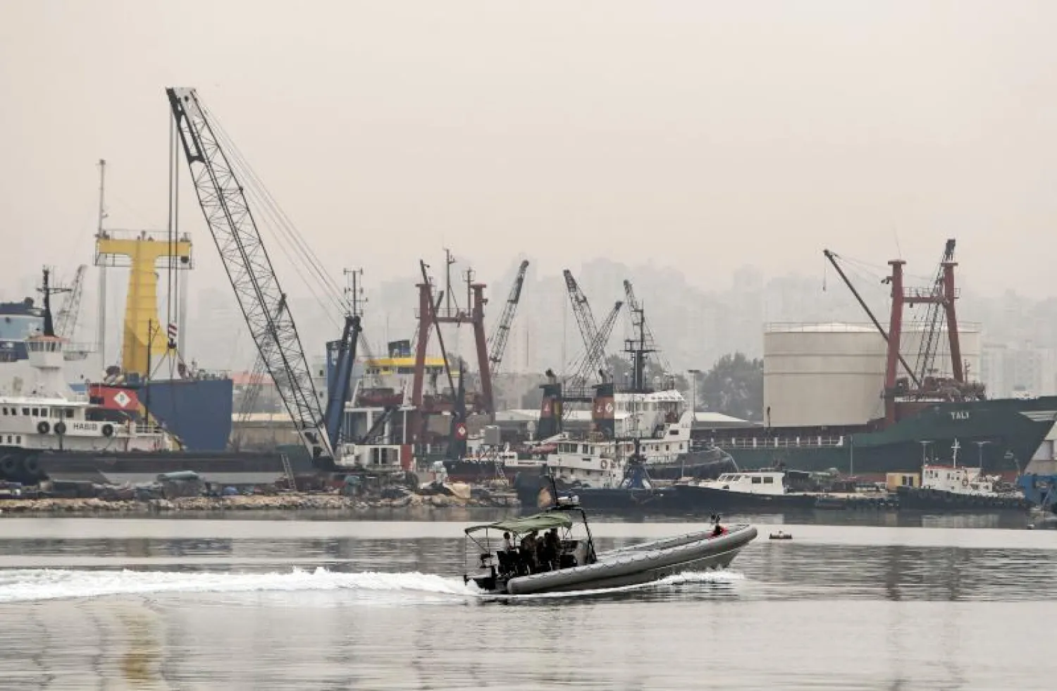 زورق تابع للجيش اللبناني يحمل ضحايا حادث الغرق في ميناء طرابلس (أ.ف.ب)