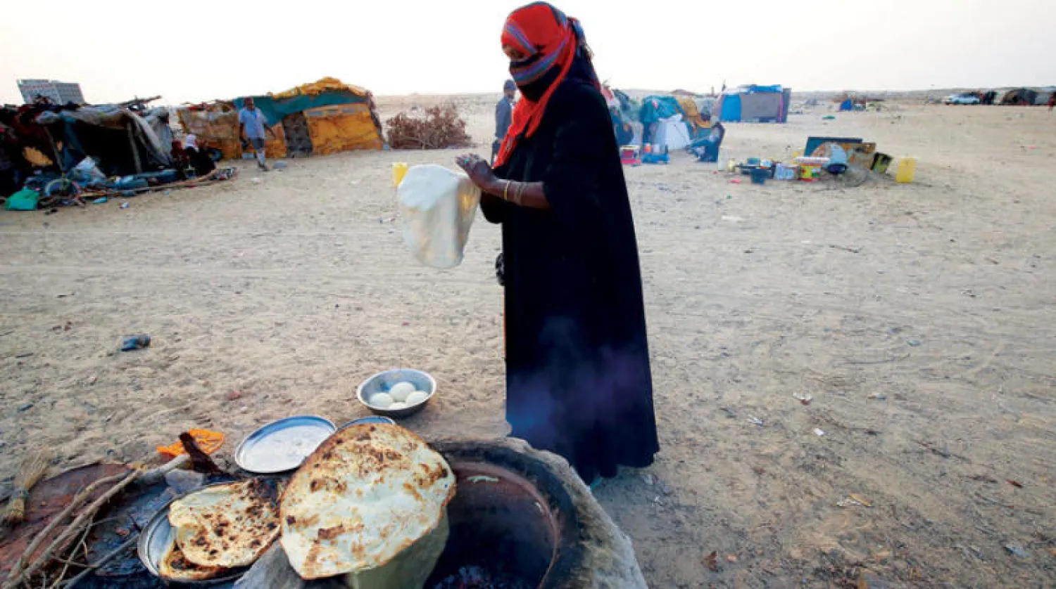 امرأة تصنع الخبز في مخيم للنازحين في الغيضة بمحافظة المهرة اليمنية ( رويترز)