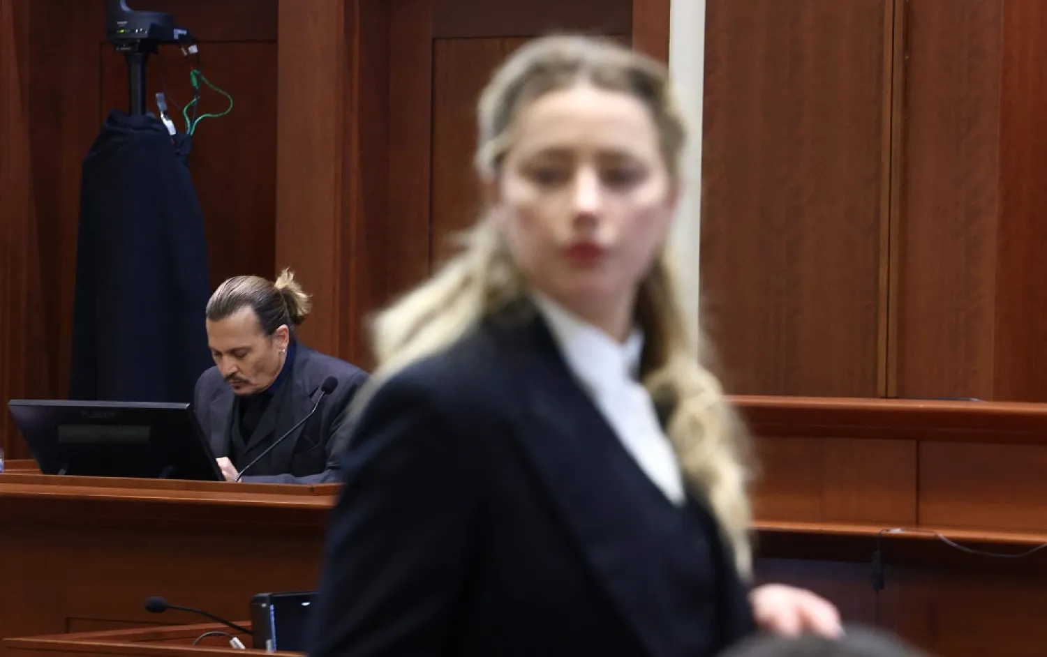 US actress Amber Heard (R) speaks to her legal team as US actor Johhny Depp (L) returns to the stand after a lunch recess during the 50 million US dollar Depp vs Heard defamation trial at the Fairfax County Circuit Court in Fairfax, Virginia, April 21, 2022. (AFP)