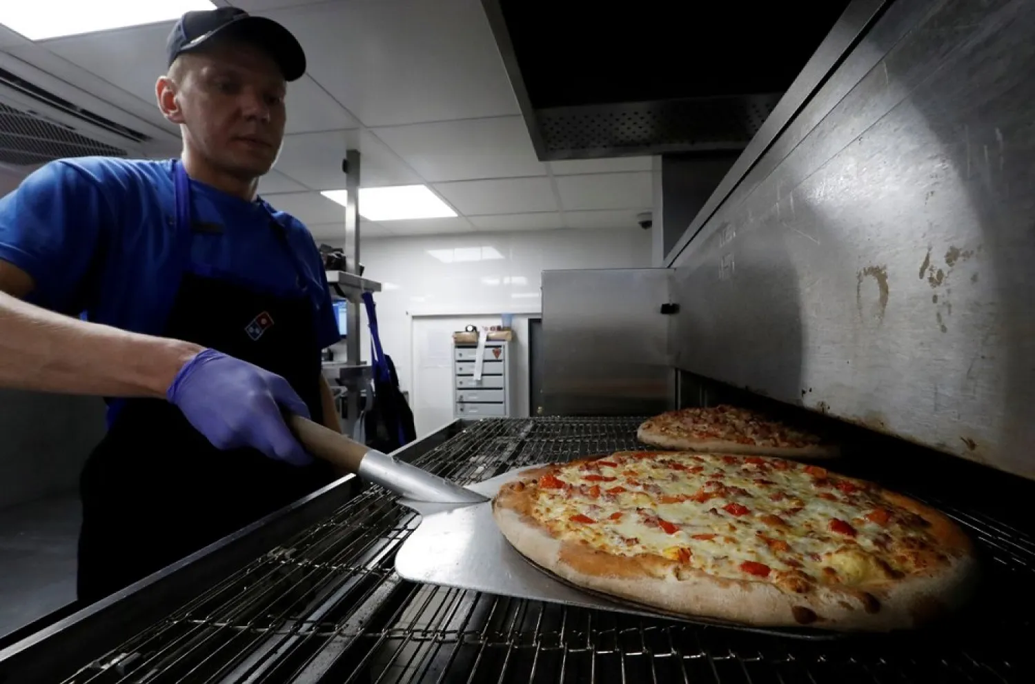 A staff member prepares pizzas at a Domino's Pizza restaurant in Moscow, Russia, July 14, 2017. Picture taken July 14, 2017. (Reuters)