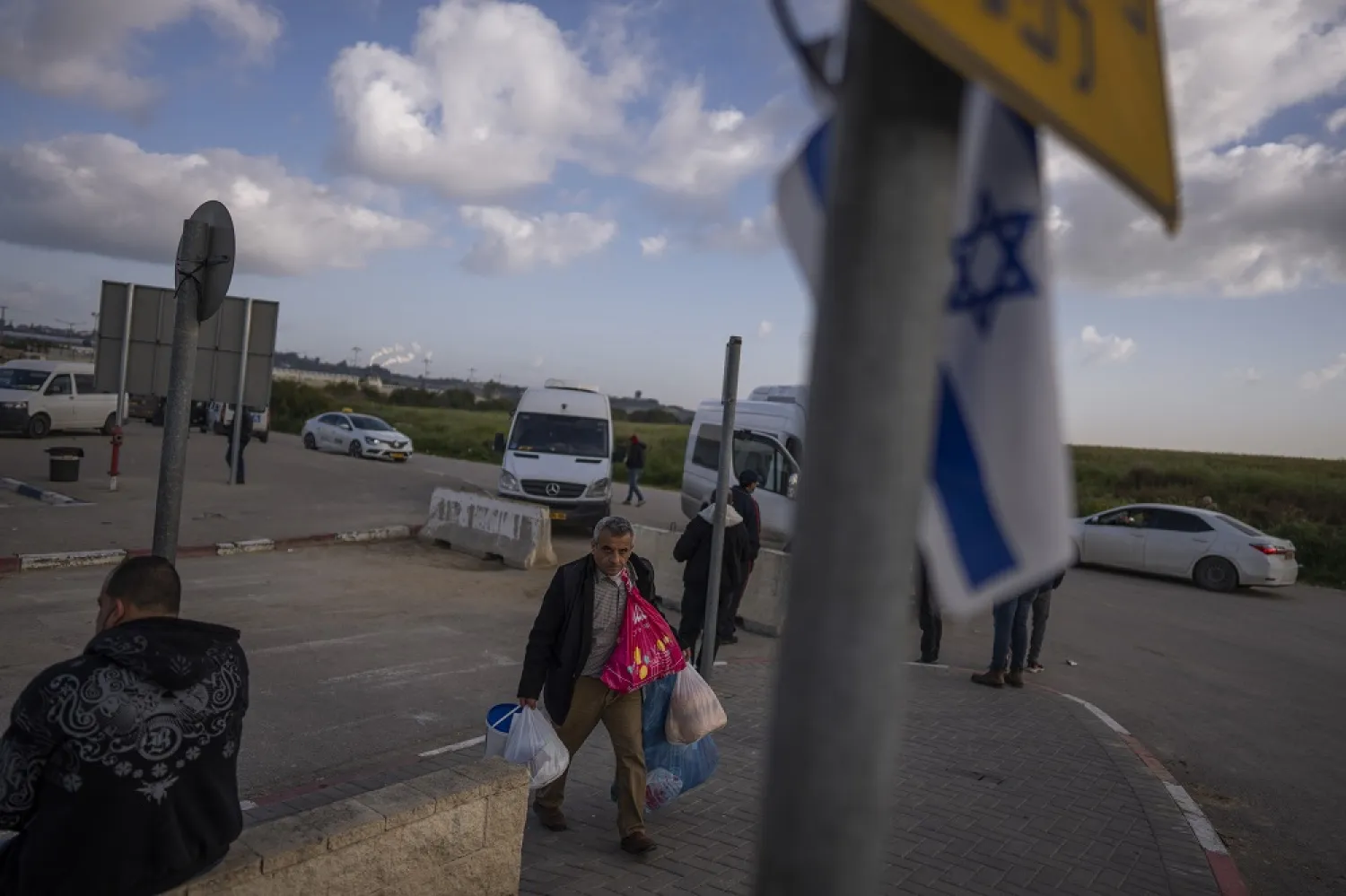 Palestinian workers wait for transportation after crossing from Gaza to Israel, on the Israeli side of Erez crossing between Israel and the Gaza Strip, March. 27, 2022. (AP)
