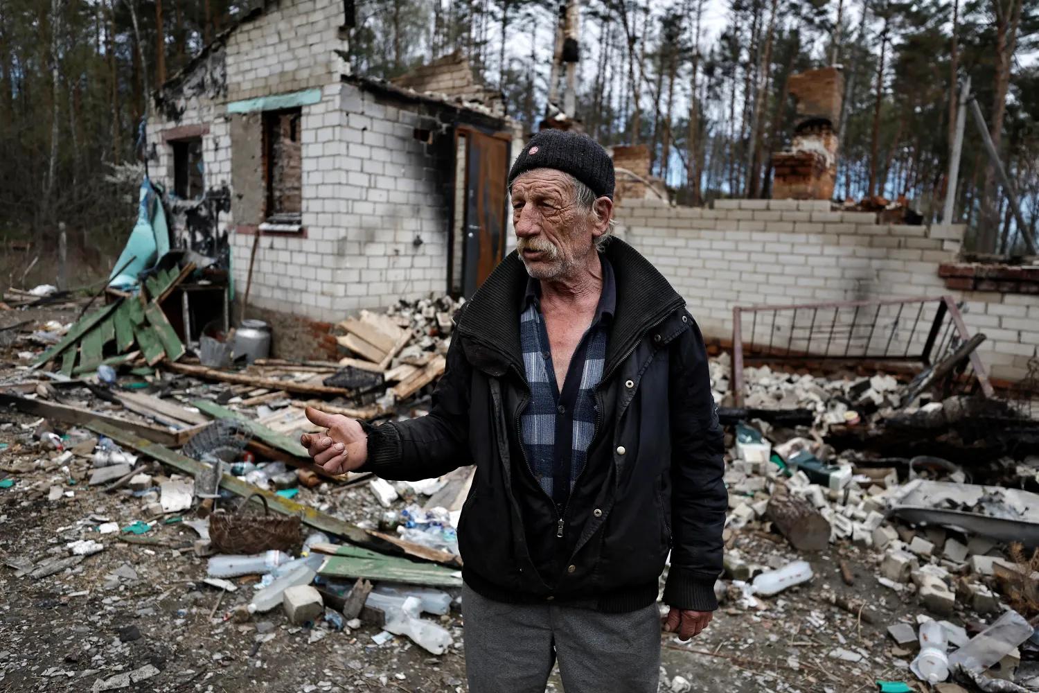 Anatolii Matukha, 70, stands outside his house, which he says was destroyed by shelling, in Yahidne, in Ukraine's Chernihiv region, on April 27, 2022. PHOTO: REUTERS
