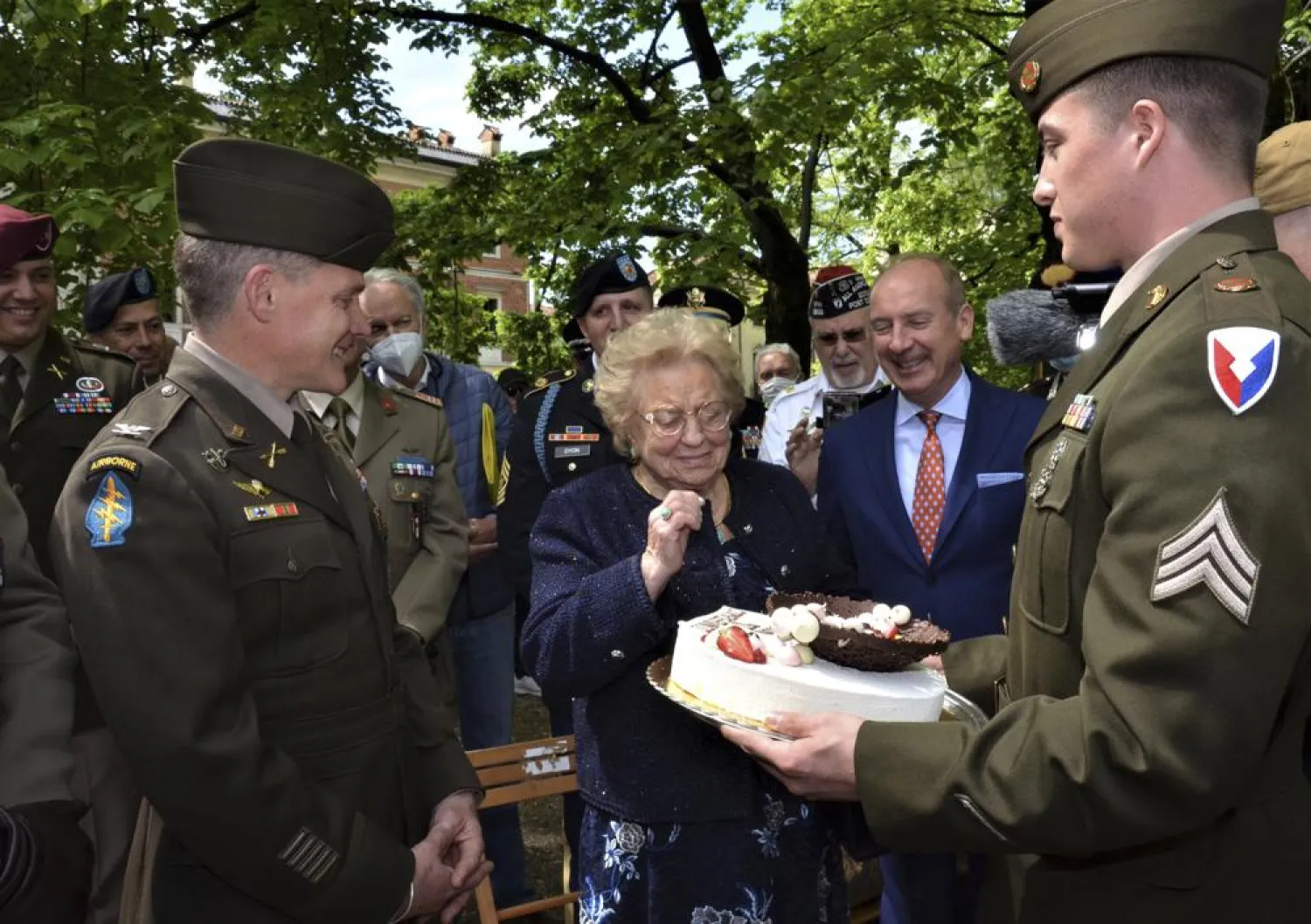Soldiers from US Army Garrison Italy return a birthday cake to Meri Mion, center, in Vicenza, northern Italy, Thursday, April 28, 2022. (US Army via AP)