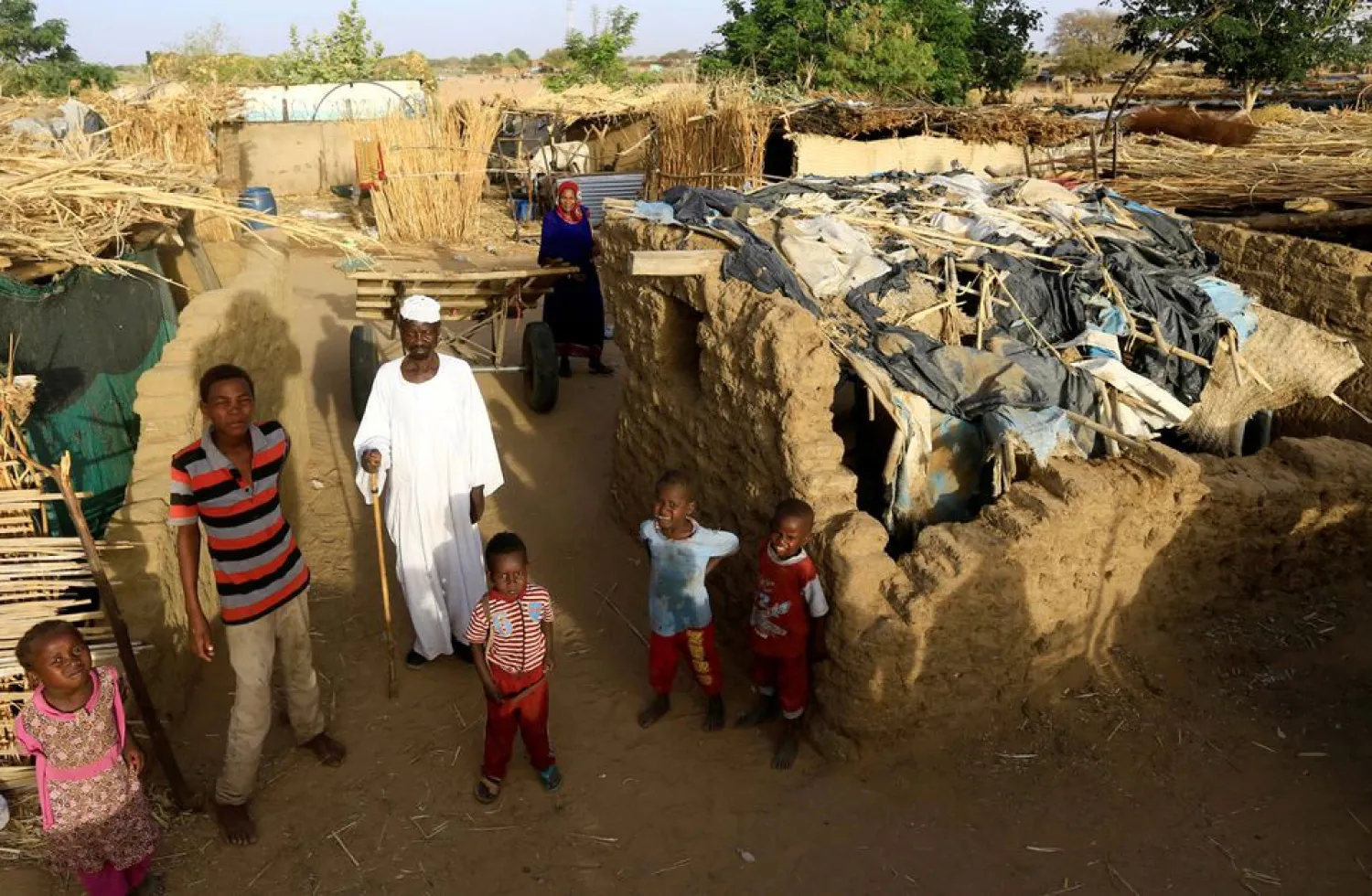 An internally displaced Sudanese family poses for a photograph outside their makeshift shelter within the Kalma camp for internally displaced persons (IDPs) in Darfur, Sudan April 26, 2019. REUTERS/Mohamed Nureldin Abdallah/File Photo