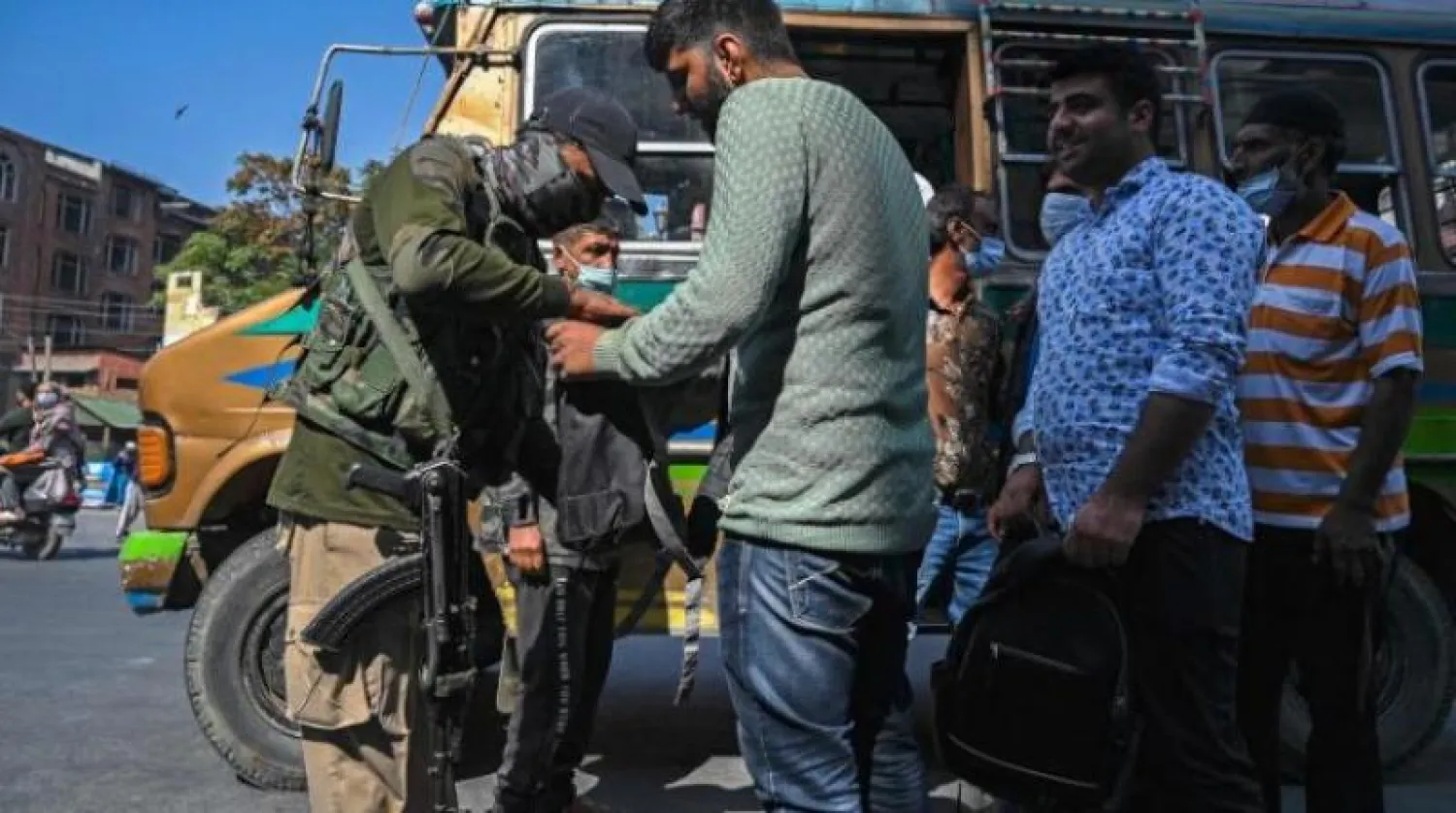 أحد أفراد الأمن يفحص حقيبة أحد ركاب حافلة على طول شارع في سريناغار (أرشيفية - أ.ف.ب)