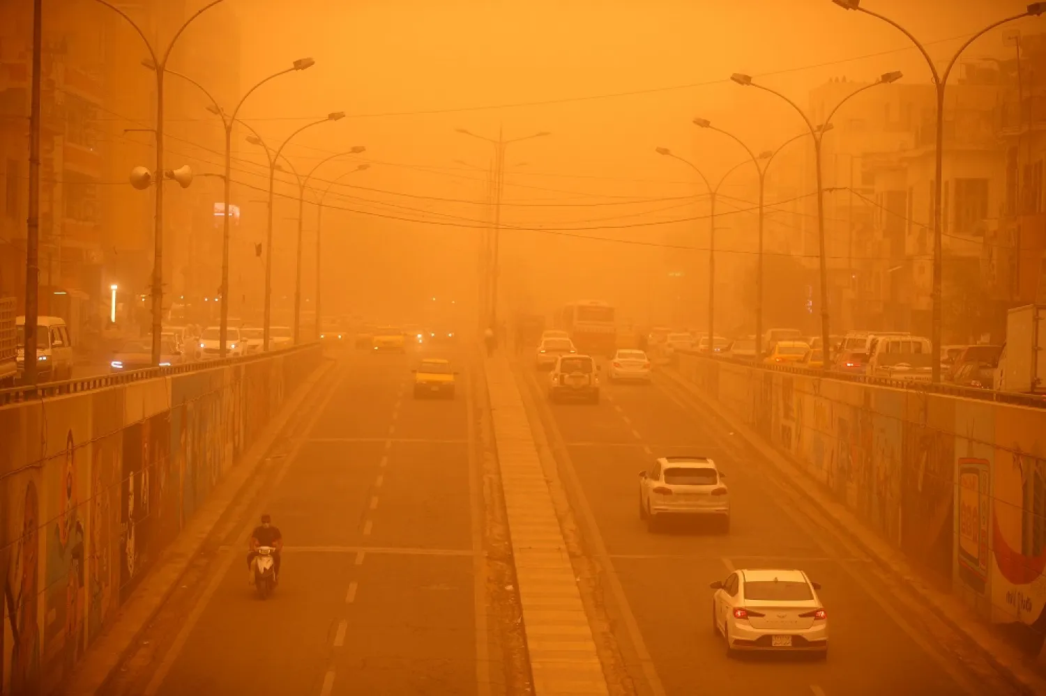 Vehicles drive along a road during a severe dust storm in Iraq's capital Baghdad on May 1, 2022. (AFP)