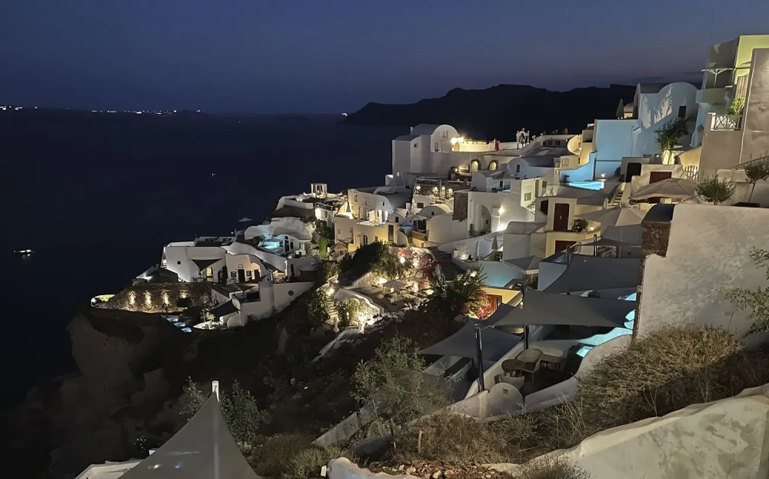 The blue lights of infinity pools and jacuzzis of luxurious hotels illuminate the village of Oia, on the island of Santorini, Greece, on Sept. 3, 2021. (AP)