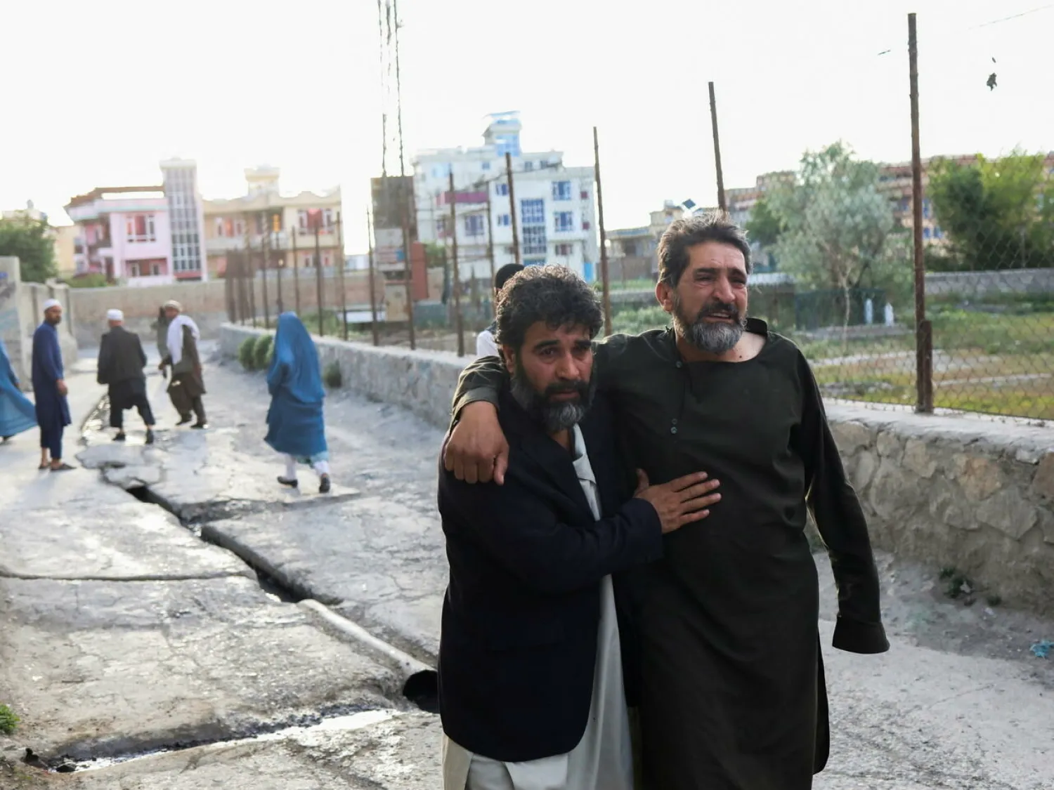 Afghan men flee near the site of explosions at Khalifa Sahib Mosque in Kabul, Afghanistan on April 29 2022. © Ali Khara, Reuters
